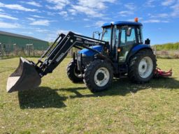 New Holland TD 90D traktor med frontlæsser og græsklipper.