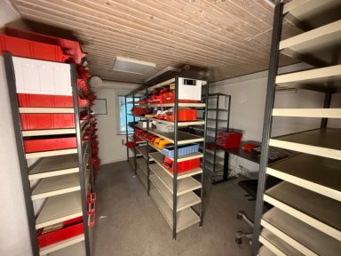 Lagerrum med 11 lagerreoler, skrivebord og el-komponenter